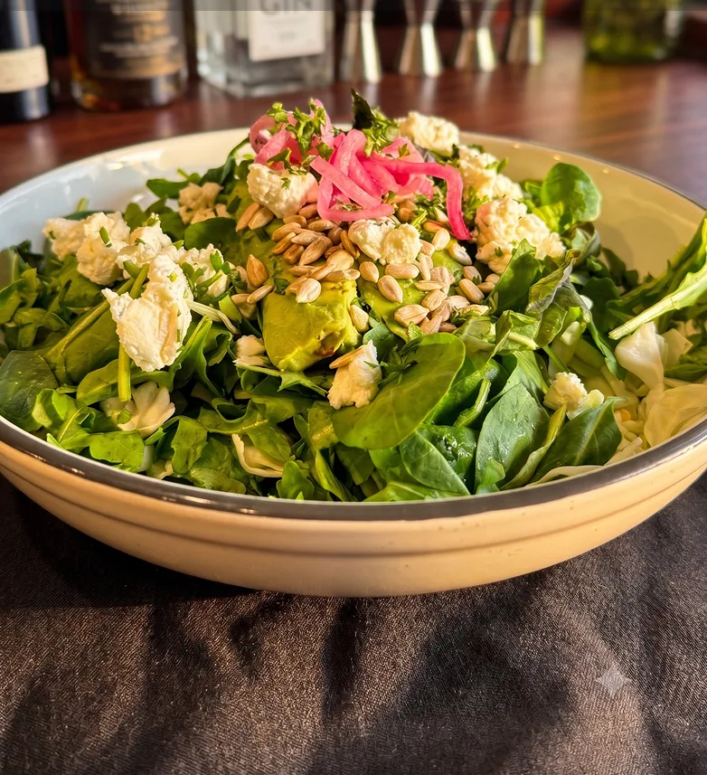 Kale and leafy greens salad with avocado, sunflower kernels, goat cheese, and sweet onion mustard dressing at Maisie&rsquo;s Green Brae