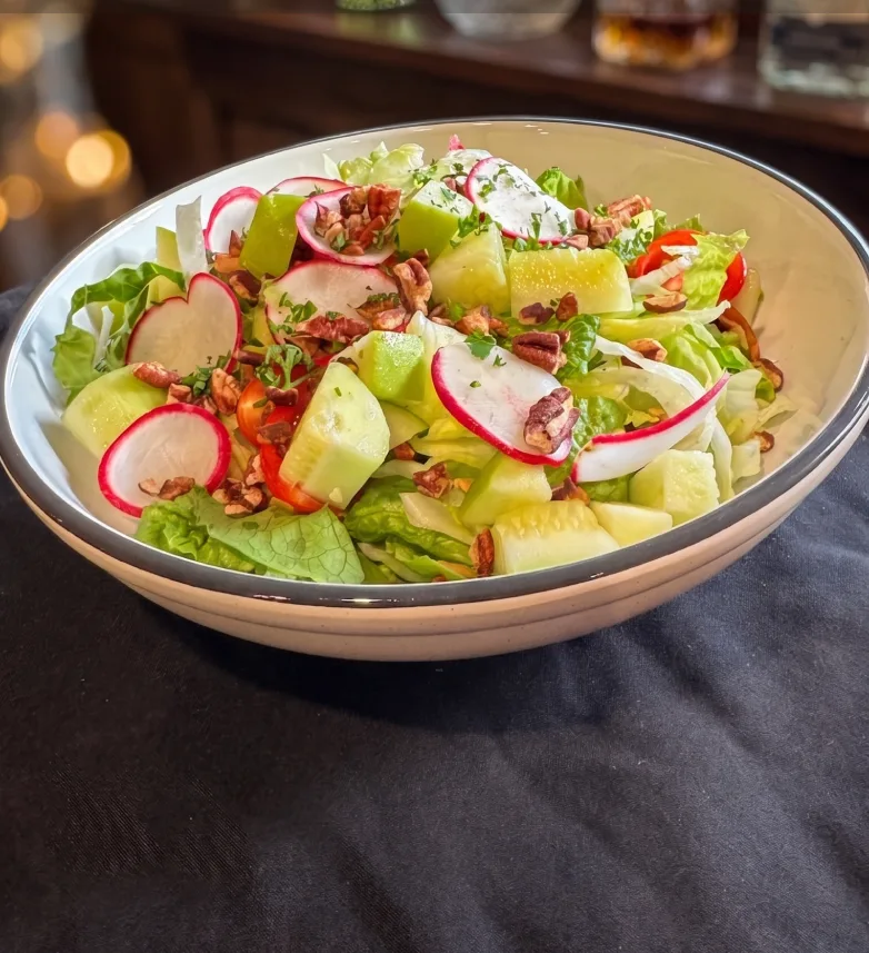 Sweet and savory chopped salad with tomato, cucumber, radish, green apple, pecans, and green goddess dressing at Maisie&rsquo;s Green Brae
